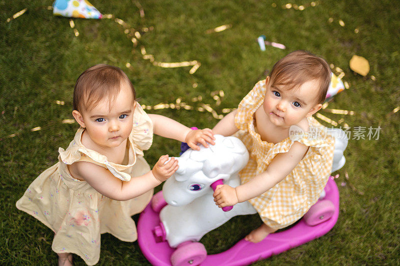 双胞胎姐妹在生日聚会上玩小马玩具