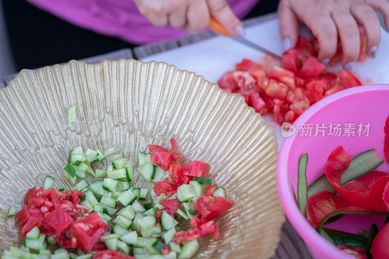 白人妇女站在厨房准备食物，切蔬菜