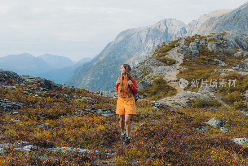 一位女性徒步旅行者在挪威的山上欣赏秋天