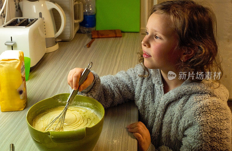 这个孩子是一个白种女孩，7岁，正在厨房里准备做披萨的面团。孩子帮妈妈做家务。