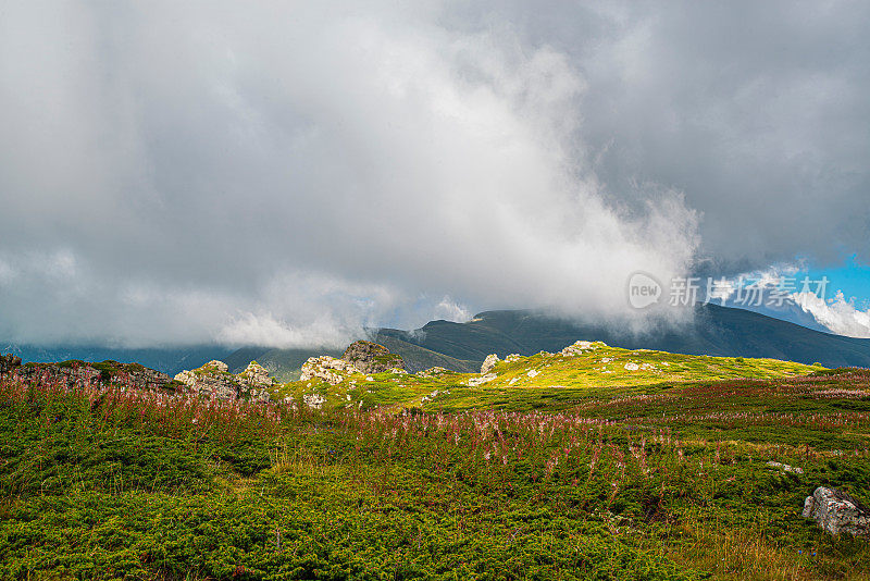 在一个阳光明媚的夏日里，有美丽的山峦和岩石景观。