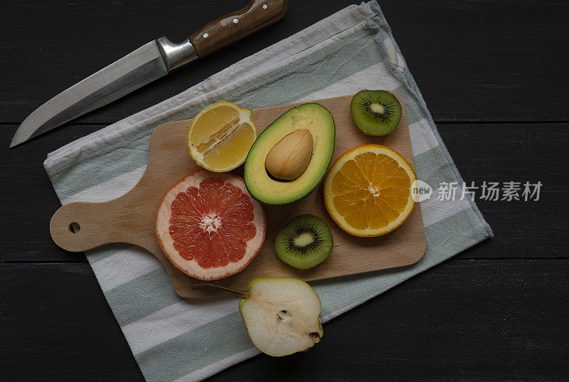 在砧板上用刀把水果和蔬菜切一半作为素食背景