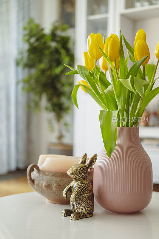 黄色的郁金香插在咖啡桌上的花瓶里。