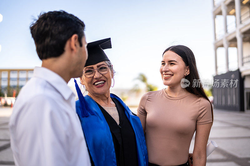 毕业典礼上，一位女毕业生一边拥抱女儿和儿子一边说话