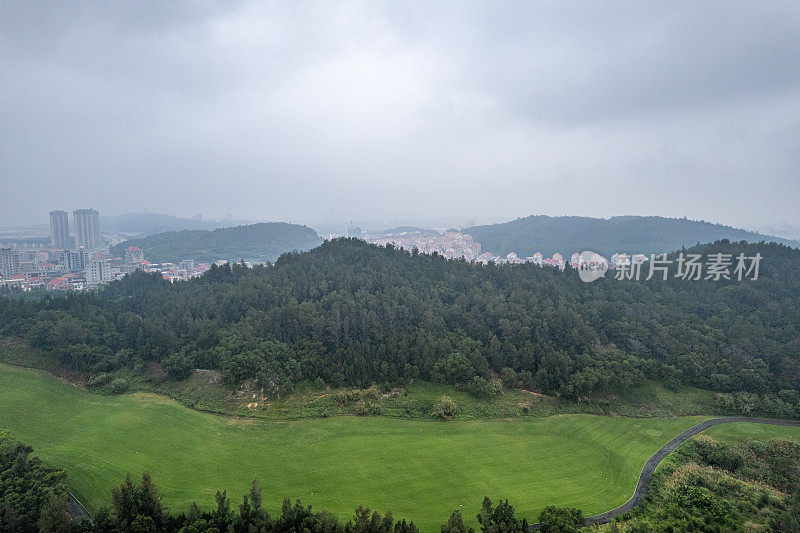 雾天高尔夫球场建筑和草坪的鸟瞰图