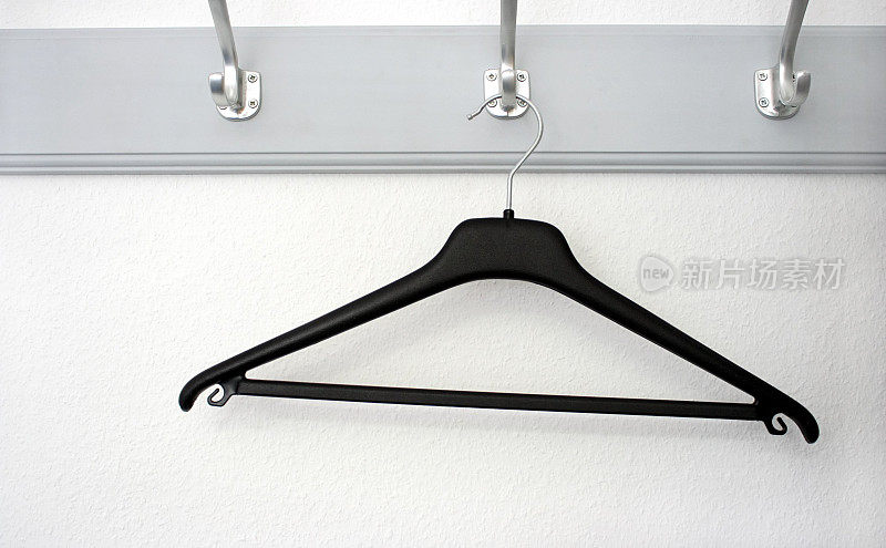 衣柜挂钩上的一个黑色塑料衣架