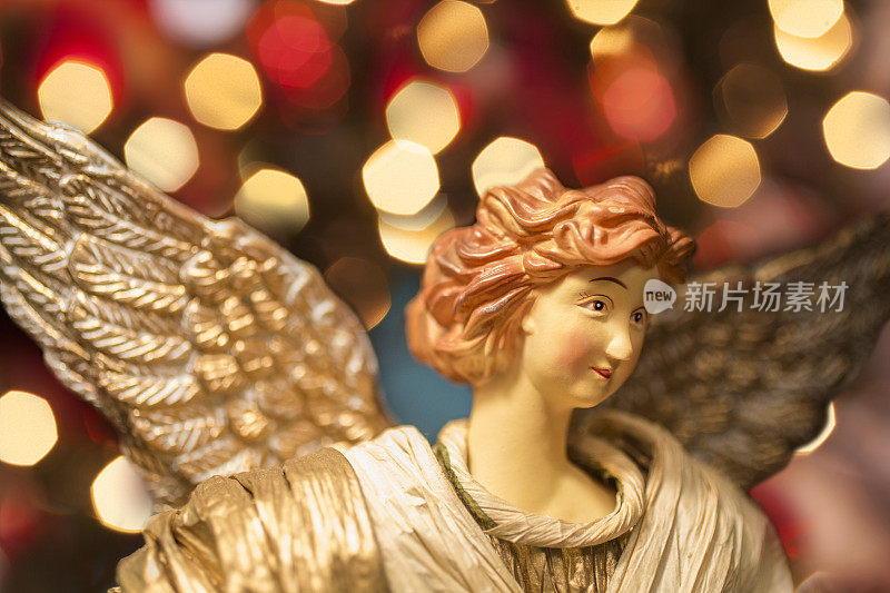 圣诞天使与节日灯的特写。