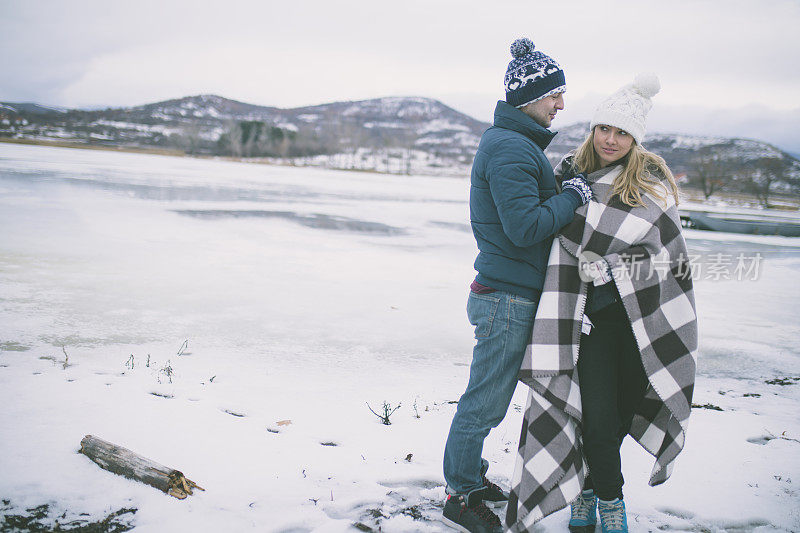 在冬天，一对夫妇在温暖的格子毯子里拥抱