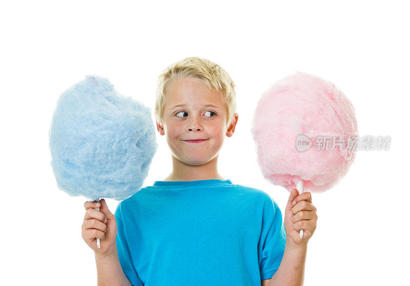 一个小男孩拿着粉色和蓝色的棉花糖