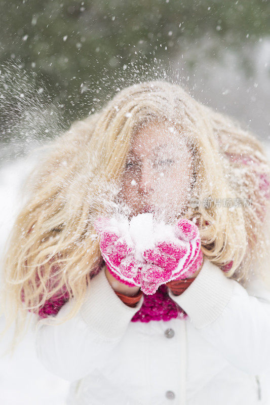 女人从粉色手套上吹雪