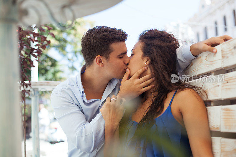 快乐的年轻情侣在咖啡馆接吻