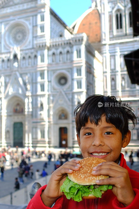 男性幼儿吃垃圾食品。意大利佛罗伦萨的圆顶。