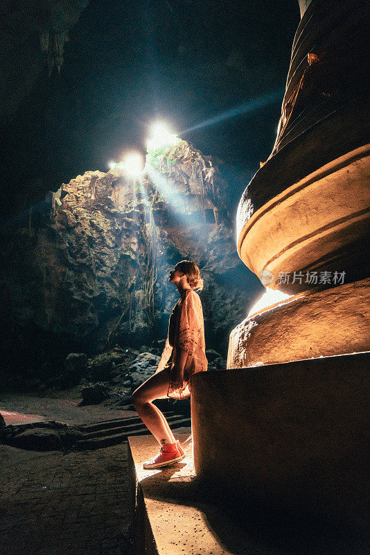 女人坐在佛寺的山洞里