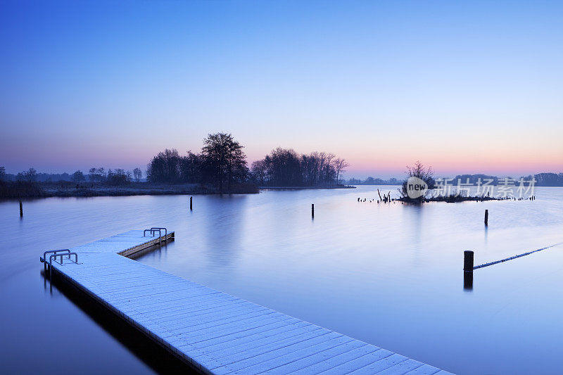 在一个霜冻的冬日早晨，码头在静静的湖面上
