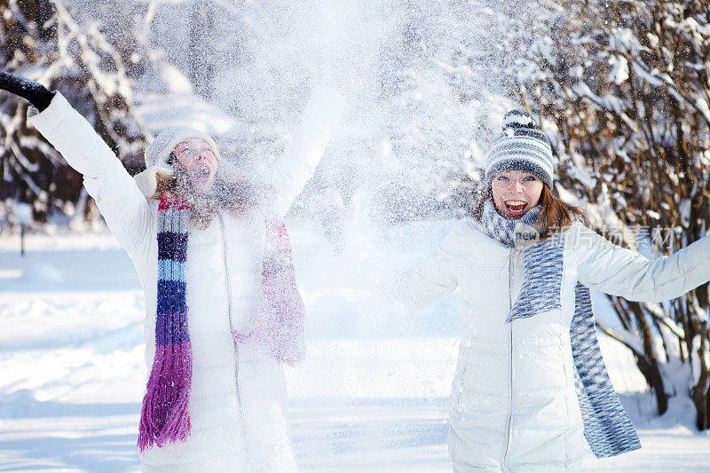 冬天。女孩玩雪球。