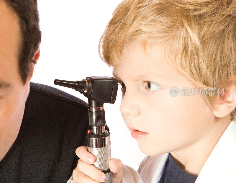 扮演医生的孩子用耳镜检查耳朵