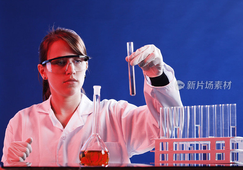 年轻的女科学家在试管中检查化学物质，努力集中注意力