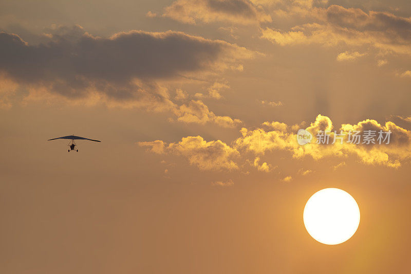 夏日太阳上空的超轻型飞机