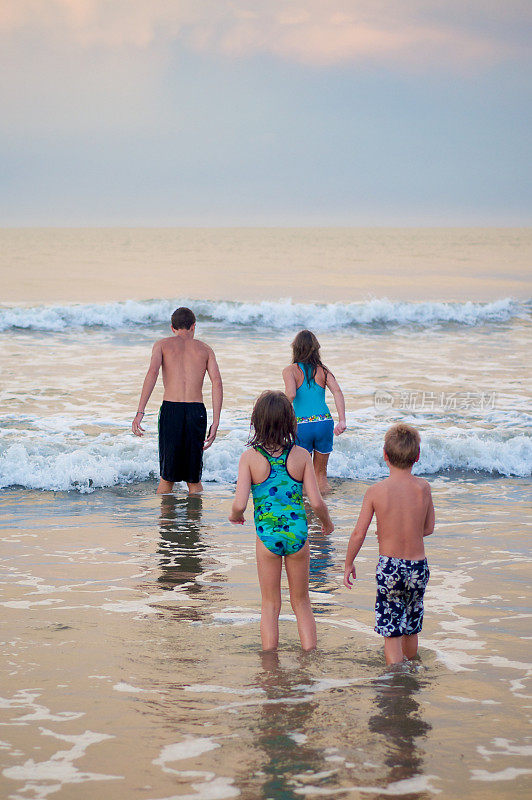四个孩子走进海浪