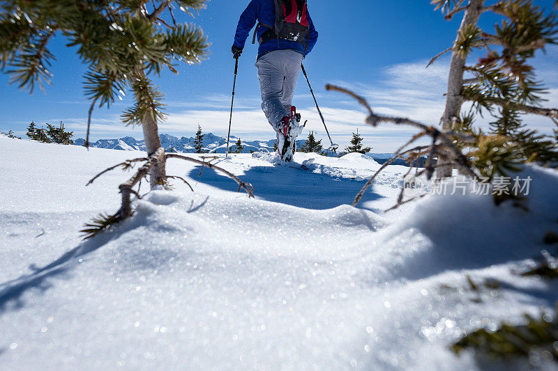 滑雪者在Backcountry皮肤在风景优美的山区地形