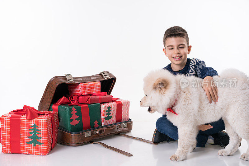 松狮犬小狗和带圣诞礼物的小男孩