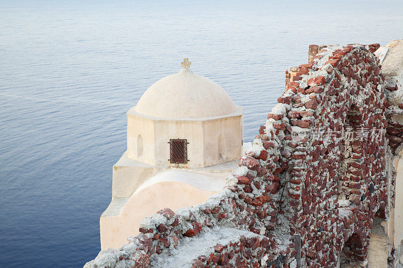 日落时分伊亚村的传统教堂。圣托里尼岛。希腊。