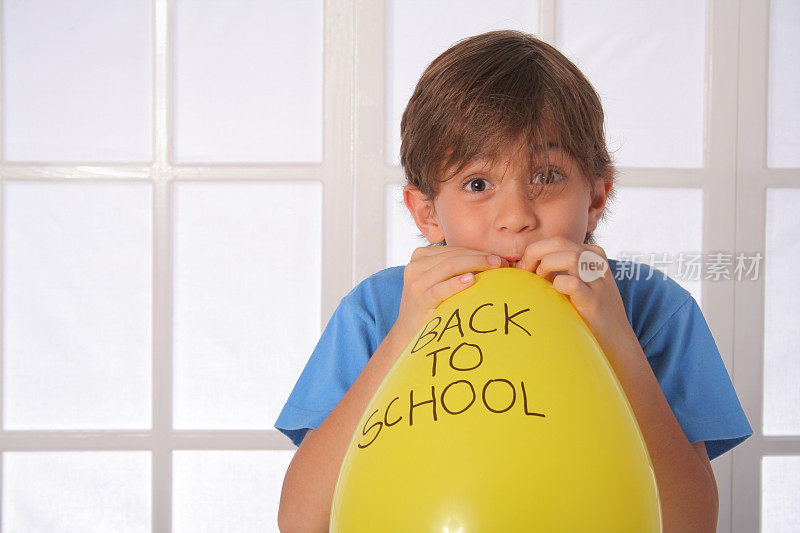 用黄色气球返回学校的男孩