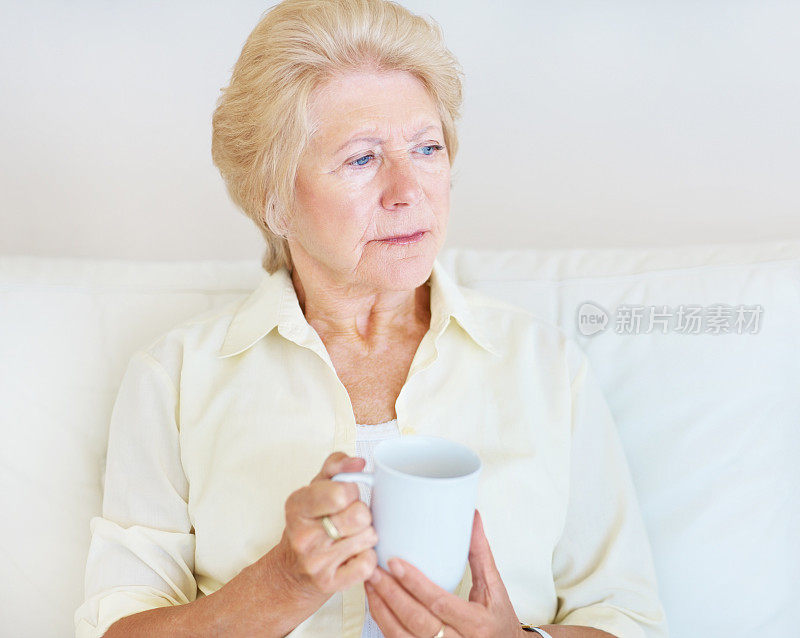 举着咖啡杯沉思的老年妇女