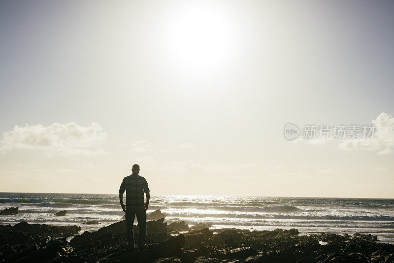 在小菲斯特海滩傍晚的阳光下背光的男人