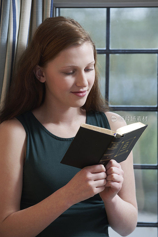 十几岁的女孩在家里读圣经