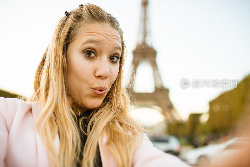 一名女子在巴黎埃菲尔铁塔上自拍