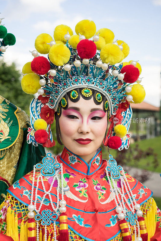 美丽的中国女孩穿着中国传统服饰和帽子站在户外