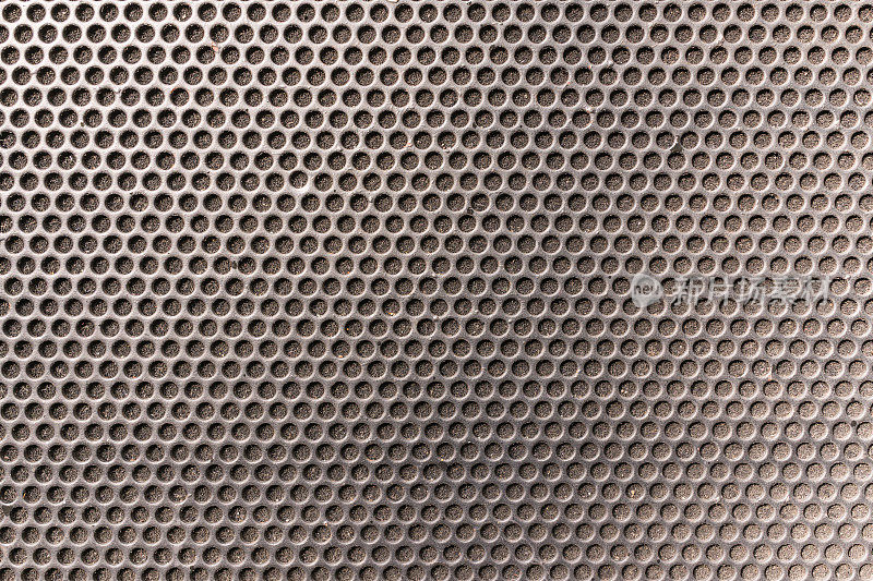 音乐音箱前的金属蜂窝六边形格栅图案作为背景