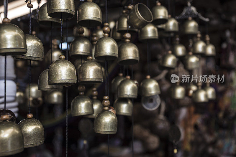许多小的黄铜铃铛挂在亚洲的小纪念品商店