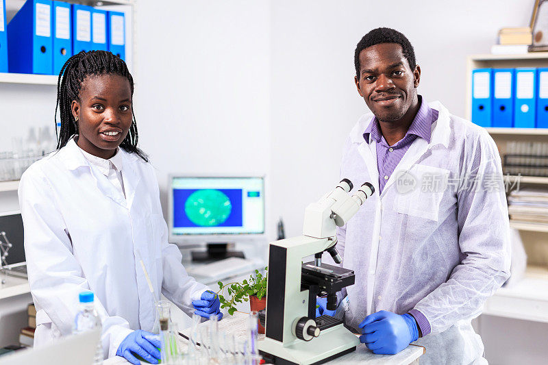 一对非洲实验室工作人员使用显微镜