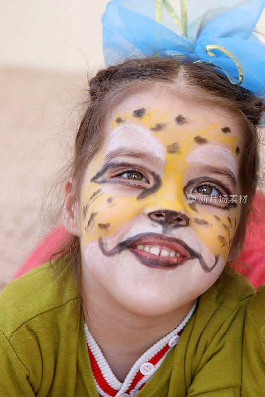 微笑的小女孩，她的脸画得像一只猎豹