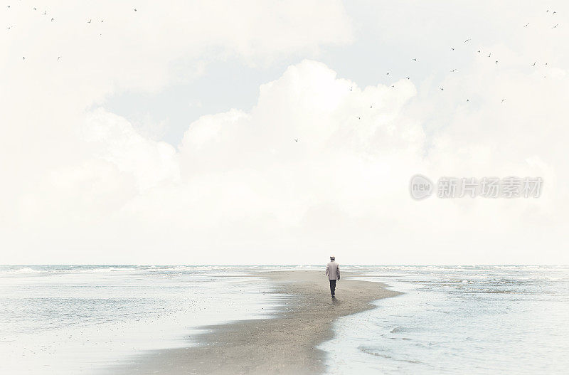 平静的人走在两海之间的沙滩上