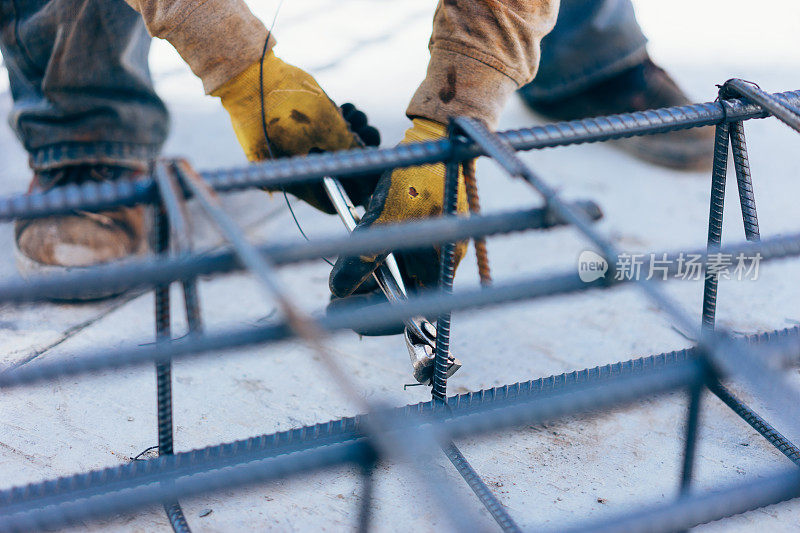 建筑工人用铁丝固定钢筋以加固水泥