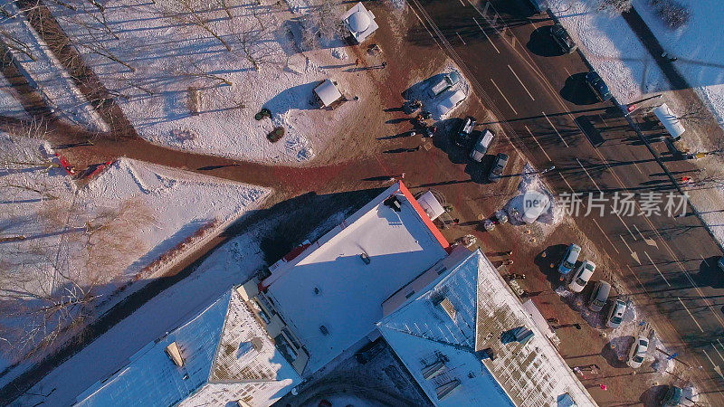 俯视图，正上方鸟瞰被雪覆盖的冬季城市住宅区。攀爬和旋转复杂的摄像机运动。