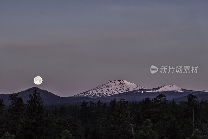 在美国俄勒冈州中部的喀斯喀特山脉，满月正落在学士山上