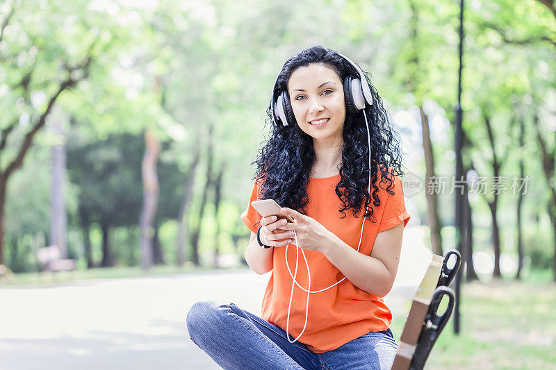 年轻女子在用智能手机听音乐