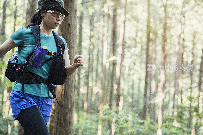 健身女性越野跑者在山间小路上跑步