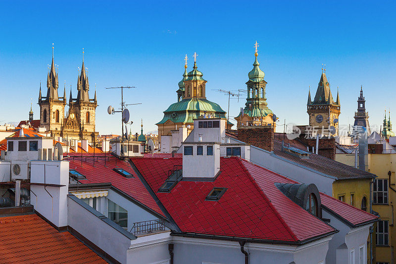捷克共和国布拉格的房屋、教堂和教堂的屋顶。明亮的瓦片屋顶映衬着蔚蓝的天空。