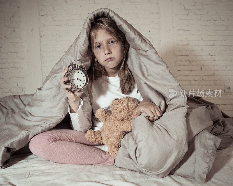 可爱的不眠之夜的小女孩坐在床上看起来悲伤和疲倦有睡眠问题晚上睡不着或早上醒来太早在失眠焦虑儿童睡眠障碍。