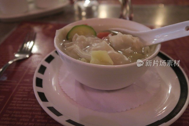 中餐馆里的鸡肉馄饨的图片，配菜勺子，中国饺子碗和东方亚洲蔬菜汤的照片