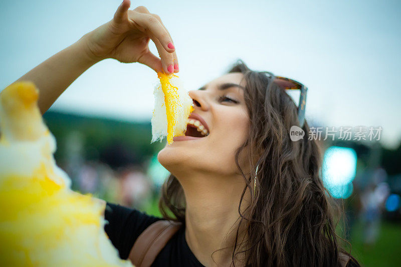 一个在音乐节上吃糖羊毛的女人