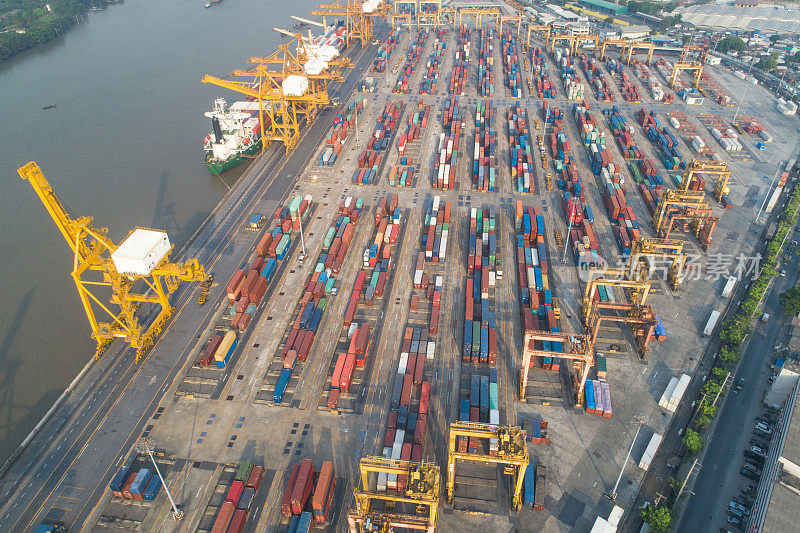 集装箱货轮的物流运输和货物与工作起重机桥在日出船厂，物流进出口和运输行业背景