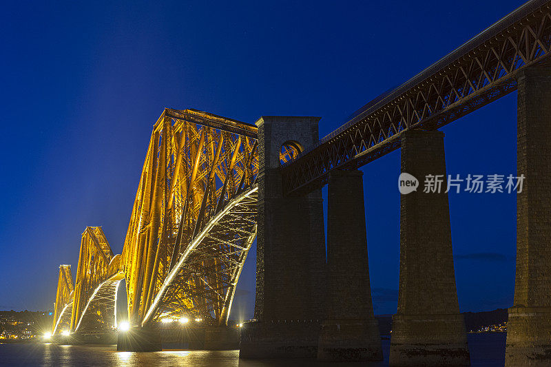 黄昏时照亮英国苏格兰爱丁堡的福斯湾铁路桥。