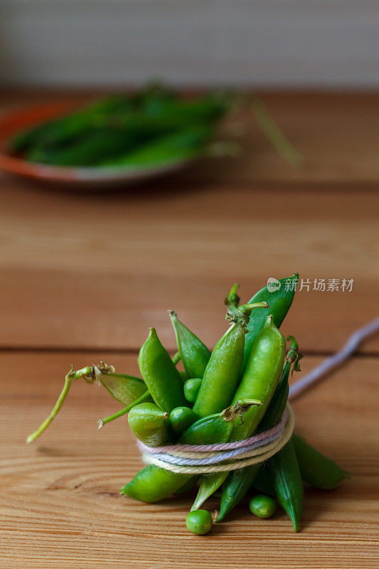 木板背景上的新鲜豌豆