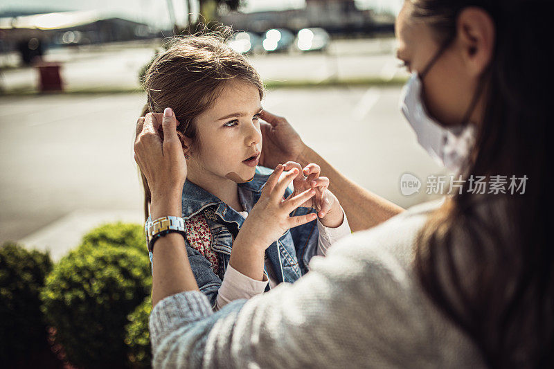 带着女儿戴着防护面具购物的女人